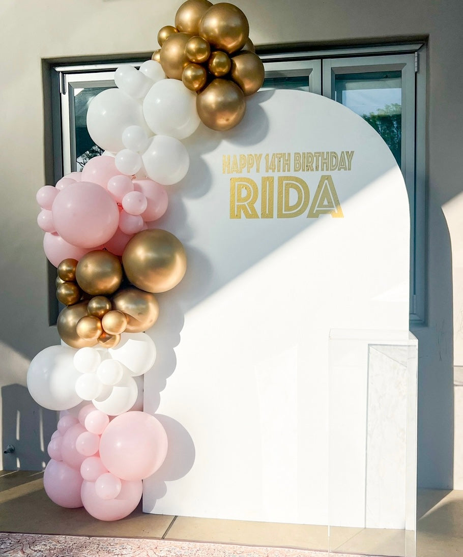Arch board with balloon garland decoration services backdrop for hire for birthdays with custom signage and cake stand 