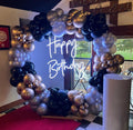 Balloon garland on round ring backdrop with happy birthday neon and cake stand event decorations for hire for birthday event 